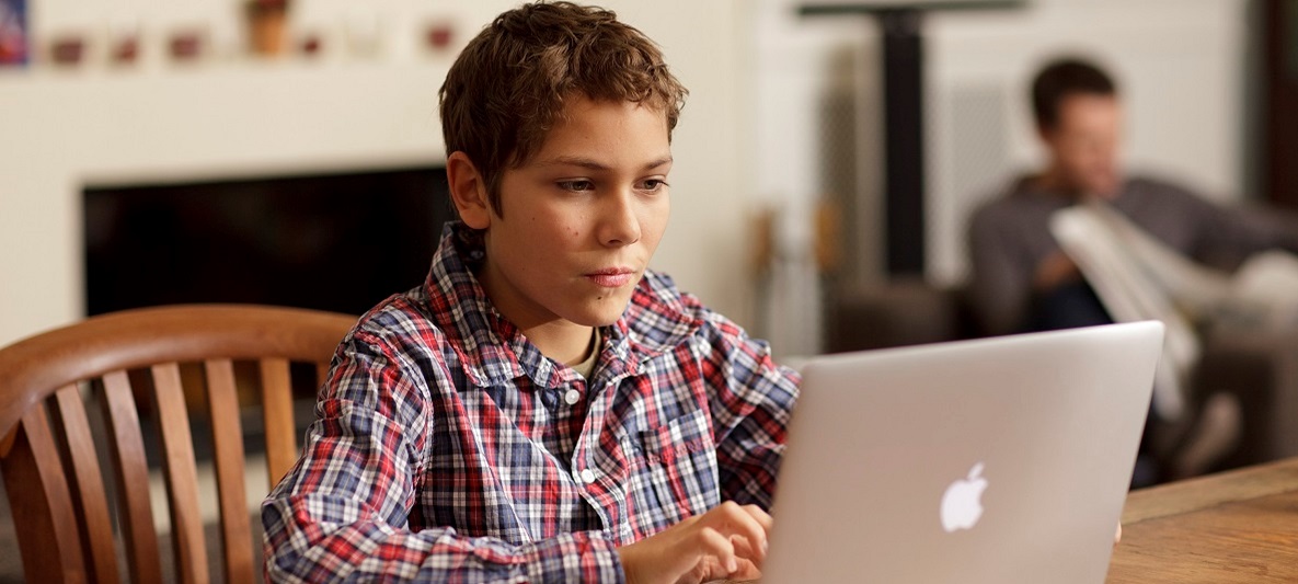 Junge schaut auf Laptop Junge schaut auf Laptop